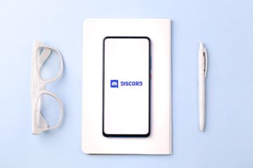An image featuring a phone that has Discord opened on it