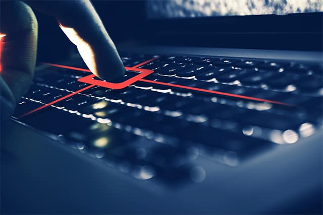An image featuring a person that has his finger on his keyboard with red mark representing keylogger spyware concept