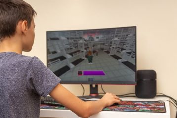An image featuring a teenager playing Roblox on his PC concept