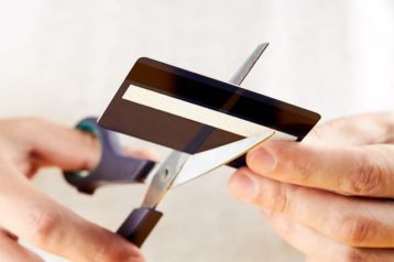 An image featuring a person cutting his credit card concept