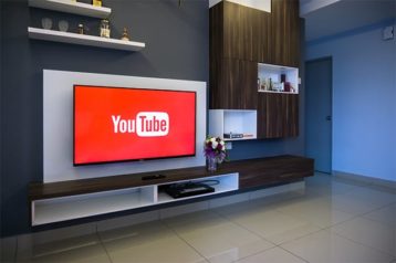 An image featuring a living room with the TV being turned on showcasing YouTube TV features concept