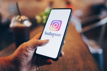 An image featuring a person using Instagram on their phone