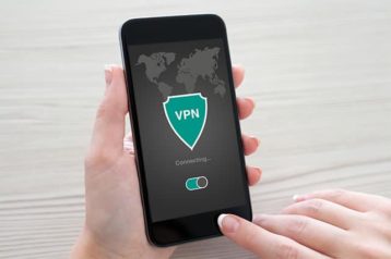 An image of a person holding his phone and using a VPN service