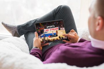 An image featuring a person watching NBA livestreaming on his tablet