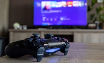 An image of a ps4 controller in front of a television