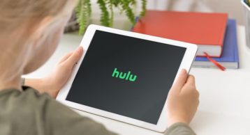 an image of a younger person enjoying HULU on her tablet
