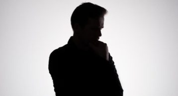 a man in a shadow showcasing him thinking