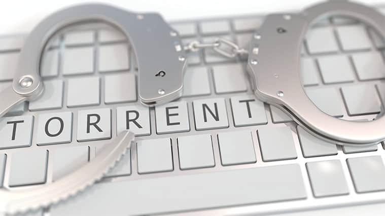 An image featuring a keyboard with handcuffs on top of it that says torrent representing illegal torrenting