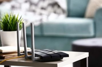 An image featuring a router in a living room with a plant next to it