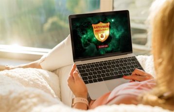 An image featuring a person using her laptop with an antivirus protection opened concept