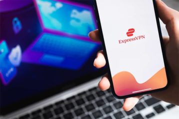 An image featuring ExpressVPN app on mobile phone with a laptop in the background that has a VPN connection concept