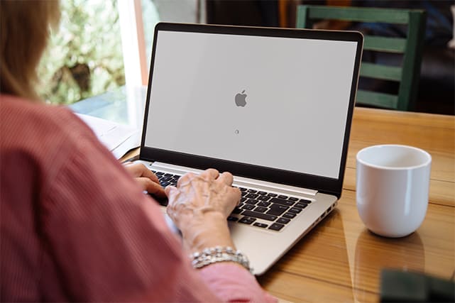 An image featuring a person starting up their Mac laptop concept