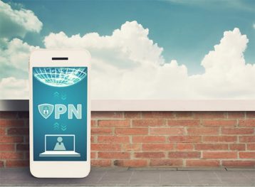 Bir duvarın yanında duran ve BT konseptinde güvenli bir VPN bağlantısı olan bir cep telefonu içeren bir resim