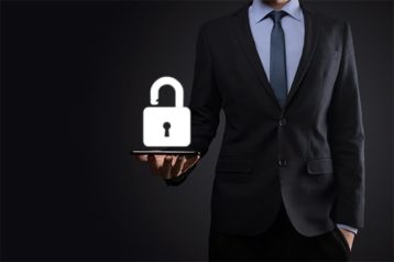 An image featuring a person standing and holding a padlock representing security concept