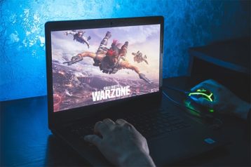 An image featuring a person gaming Call of Duty Warzone on laptop concept
