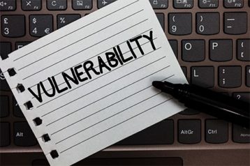 a paper with text "vulnerability" and a marker on top of a laptop keyboard