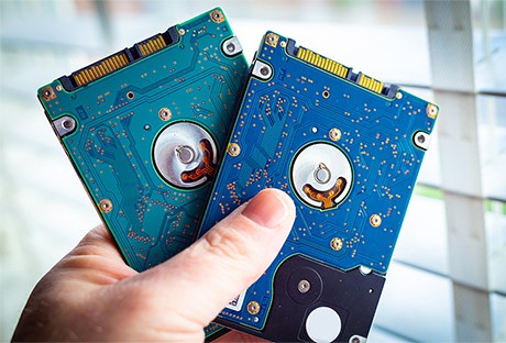 an image with two hard drives in persons hand 
