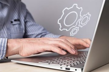 an image with person using laptop and settings icon 