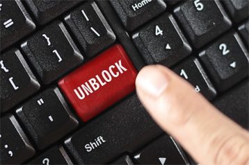 an image with finger touching unblock button on keyboard 