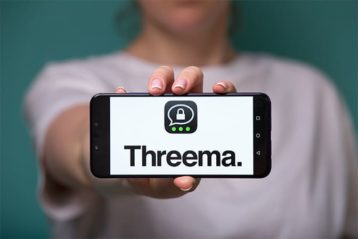 an image with woman holding smartphone with Threema application on it 
