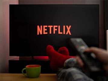 an image with person watching Netflix on TV