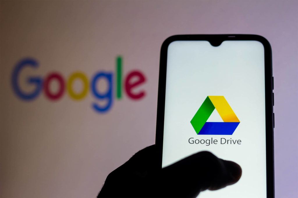an image with google drive opened on smartphone with google logo in background 