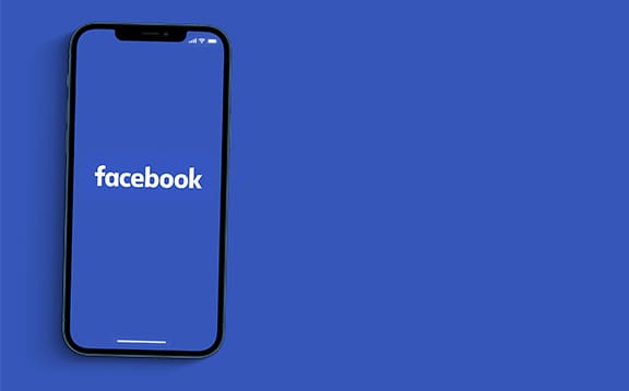 an image with Facebook app opened on smartphone in blue background 