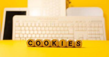 an image with cookies written on cubes in front of keyboard