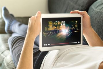 an image with a person watching a movie on tablet in bed 