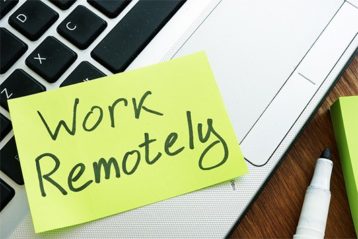 an image with work remotely note stick on laptop keyboard 