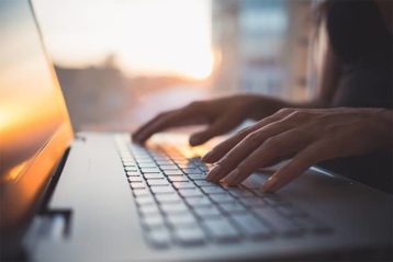 an image with woman typing on laptop